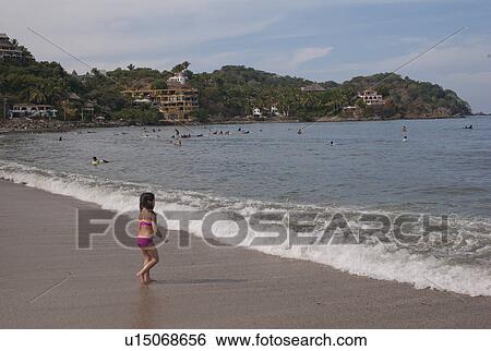 Stock Photograph - Girl walking on the beach, Sayulita, Nayarit, Mexico. Fotosearch