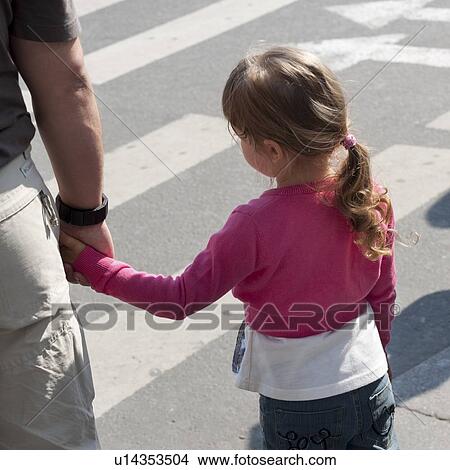 Girl with her father crossing a road, St. Petersburg, Russia View Large Photo Image Picture - Girl with her father crossing a road, St. Petersburg, Russia. Fotosearch