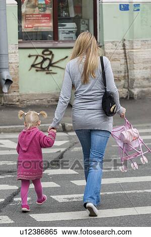 Stock Photography - Girl with her mother crossing a road, St. Petersburg, Russia. Fotosearch