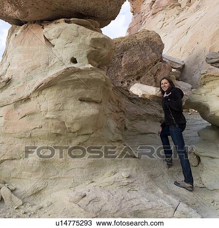 Stock Image - Happy woman moving up on rock, Utah, USA. Fotosearch