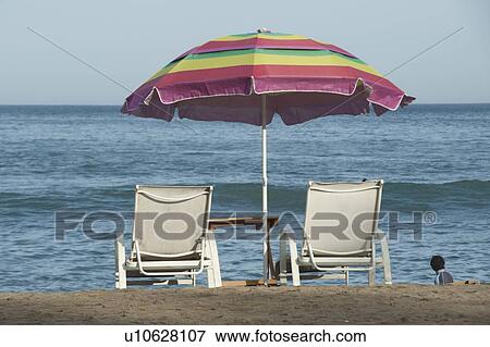 Stock Photo - Lounge chairs with a beach umbrella on the beach, Sayulita, Nayarit, Mexico. Fotosearch