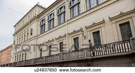 Stock Image - Low angle view of a man walking on a promenade, St. Petersburg, Russia. Fotosearch