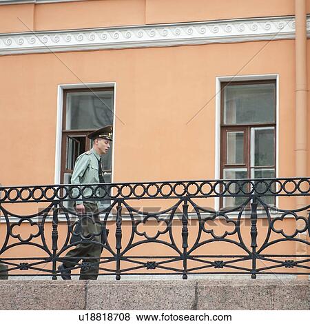 Stock Photo - Low angle view of a policeman walking in a street, St. Petersburg, Russia. Fotosearch