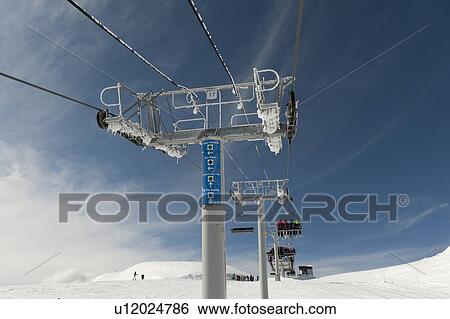 Stock Photograph - Low angle view of skiers on ski lifts, Symphony Amphitheatre, Whistler, British Columbia, Canada. Fotosearch