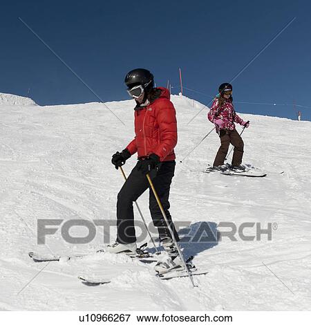Stock Photo - Low angle view of tourist skiing, Whistler, British Columbia, Canada. Fotosearch