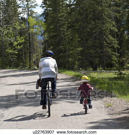Stock Photo - Man and his sun riding bicycles, Jasper National Park, Alberta, Canada. Fotosearch