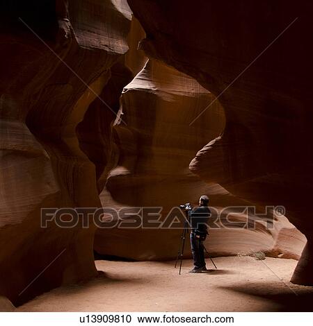 Stock Image - Man photographing in a slot canyon, Corkscrew Canyon, Lower Antelope Canyon, Antelope Canyon, Page, Arizona, USA. Fotosearch