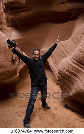 Picture - Man standing in a slot canyon with a digital camera, Corkscrew Canyon, Lower Antelope Canyon, Antelope Canyon, Page, Arizona, USA. Fotosearch