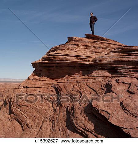 Stock Photo - Man standing on a rock, Horseshoe Bend, Glen Canyon National Recreation Area, Arizona-Utah, USA. Fotosearch