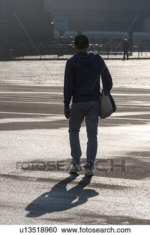 Stock Image - Man walking in a courtyard of Winter Palace, State Hermitage Museum, Palace Square, St. Petersburg, Russia. Fotosearch