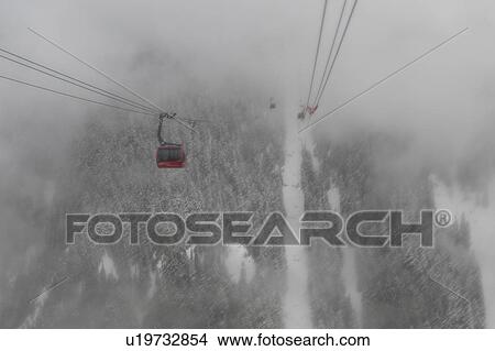 Picture - Peak 2 Peak Gondola over a foggy valley in winter, Whistler, British Columbia, Canada. Fotosearch