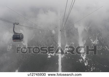 Stock Image - Peak 2 Peak Gondola over a foggy valley in winter, Whistler, British Columbia, Canada. Fotosearch