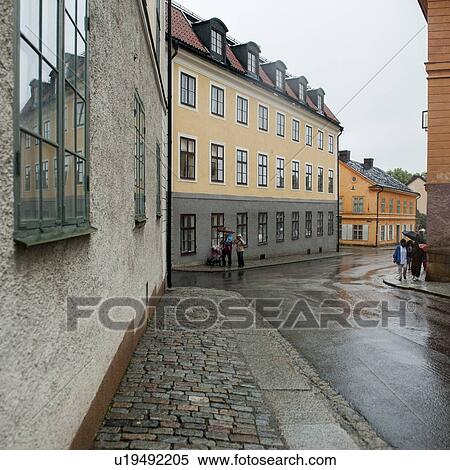 Stock Photography - People walking on a street during rain, Akademigatan, Uppsala University, Uppsala, Sweden. Fotosearch