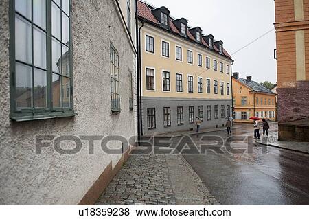 Stock Photo - People with umbrella in rain on a street, Uppsala, Sweden. Fotosearch
