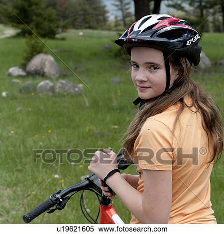 Stock Photography - Portrait of a girl riding a bicycle, Jasper National Park, Alberta, Canada. Fotosearch