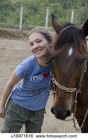 Stock Photograph - Portrait of a teenage girl standing beside a horse, Sayulita, Nayarit, Mexico. Fotosearch