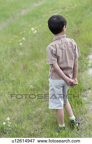 Rear view of a boy standing on grass, Jasper National Park, Alberta, Canada View Large Photo Image Stock Photo - Rear view of a boy standing on grass, Jasper National Park, Alberta, Canada. Fotosearch