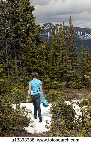 Rear view of a girl walking on snow covered trail, Bald Hills, Jasper National Park, Alberta, Canada View Large Photo Image Stock Photo - Rear view of a girl walking on snow covered trail, Bald Hills, Jasper National Park, Alberta, Canada. Fotosearch