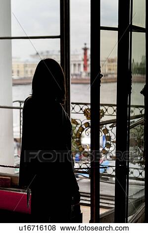 Stock Photo - Rear view of a woman looking through a window of Winter Palace, State Hermitage Museum, Palace Square, St. Petersburg, Russia. Fotosearch