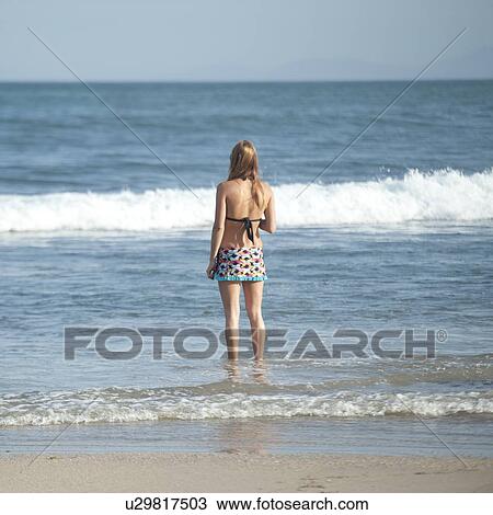 Stock Image - Rear view of woman standing on beach, Sayulita, Nayarit, Mexico. Fotosearch