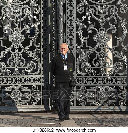 Stock Image - Security officer standing in front of a gate of Winter Palace at State Hermitage Museum, Palace Square, St. Petersburg, Russia. Fotosearch