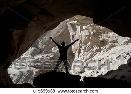 Stock Photo - Silhouette of a man standing with arms raised in Ulrike's Cave, Amangiri, Canyon Point, Utah, USA. Fotosearch