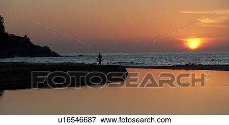 Stock Photo - Silhouette of a person walking on jetty at sunset, Sayulita, Nayarit, Mexico. Fotosearch