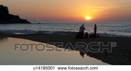 Stock Image - Silhouette of tourists on the beach at sunset, Sayulita, Nayarit, Mexico. Fotosearch