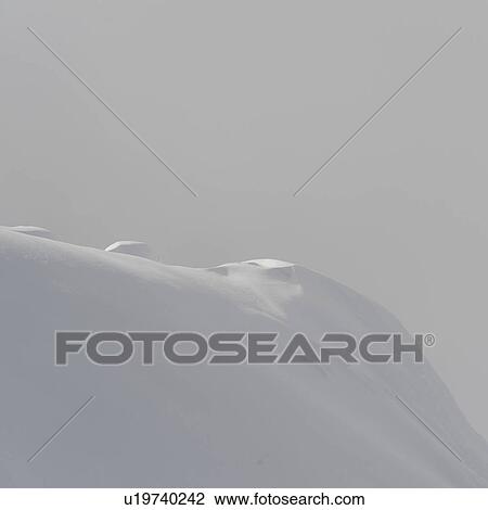 Stock Image - Snow covered mountain surrounded with fog, Whistler, British Columbia, Canada. Fotosearch