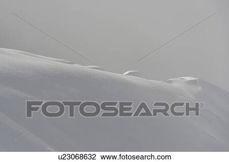 Stock Image - Snow covered mountain surrounded with fog, Whistler, British Columbia, Canada. Fotosearch