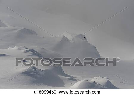 Stock Image - Snow covered mountains surrounded with fog, Whistler, British Columbia, Canada. Fotosearch