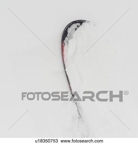 Stock Image - Snowboard buried in snow, Symphony Amphitheatre, Whistler, British Columbia, Canada. Fotosearch