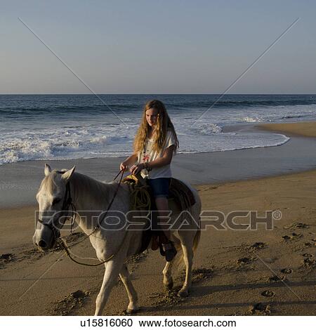 Stock Image - Teenage girl riding a horse on the beach, Sayulita, Nayarit, Mexico. Fotosearch