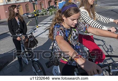 Three female friends cycling on a street, Stockholm, Sweden View Large Photo Image Stock Photograph - Three female friends cycling on a street, Stockholm, Sweden. Fotosearch