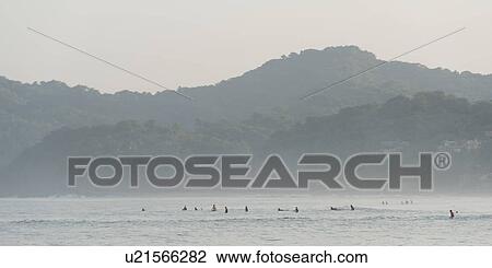 Stock Image - Tourists enjoying surfing in the sea, Sayulita, Nayarit, Mexico. Fotosearch