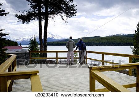 Stock Image - Tourists looking at Maligne Lake view, Jasper National Park, Alberta, Canada. Fotosearch