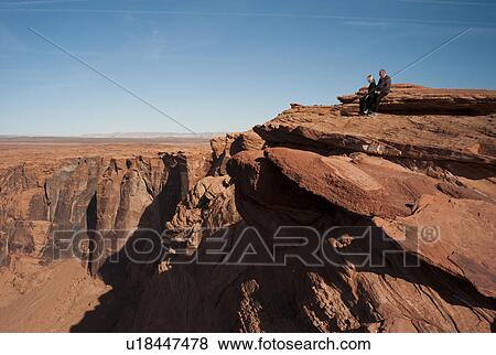 Tourists sitting on a rock looking at a view, Colorado River, Horseshoe Bend, Page, Arizona, USA View Large Photo Image Stock Photo - Tourists sitting on a rock looking at a view, Colorado River, Horseshoe Bend, Page, Arizona, USA. Fotosearch