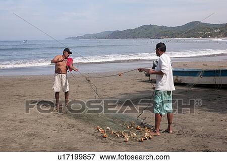 Two men holding a fishing net, Sayulita, Nayarit, Mexico View Large Photo Image Stock Photo - Two men holding a fishing net, Sayulita, Nayarit, Mexico. Fotosearch