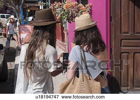 Stock Photo - Two women looking at a mobile phone, Sayulita, Nayarit, Mexico. Fotosearch