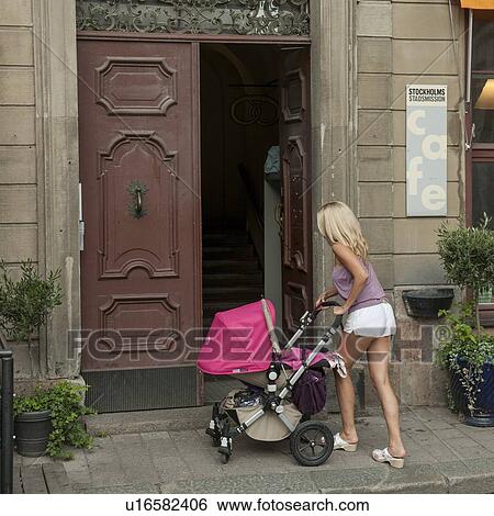 Woman at doorway with her baby in a baby carriage, Gamla Stan, Stockholm, Sweden View Large Photo Image Stock Photograph - Woman at doorway with her baby in a baby carriage, Gamla Stan, Stockholm, Sweden. Fotosearch