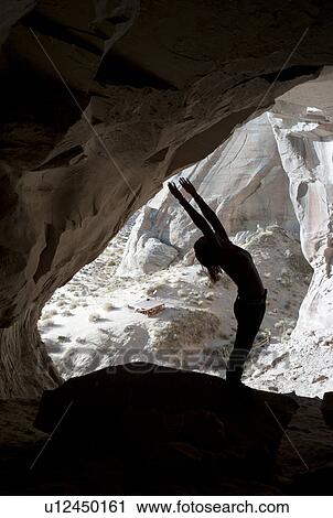Stock Image - Woman exercising in Ulrike's Cave, Amangiri, Canyon Point, Utah, USA. Fotosearch