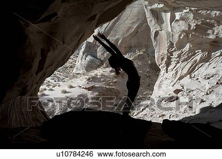 Stock Photograph - Woman exercising in Ulrike's Cave, Amangiri, Canyon Point, Utah, USA. Fotosearch