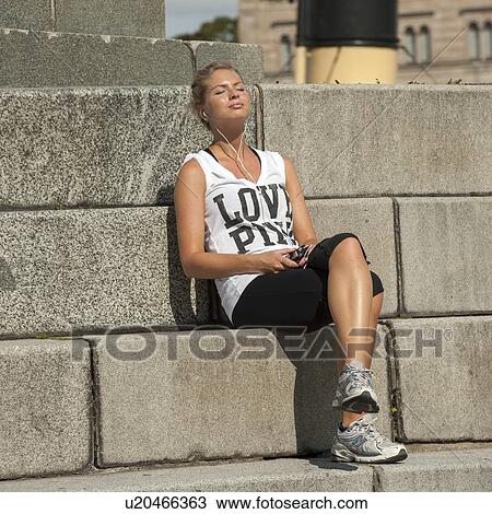 Woman listening to an MP3 player, Stockholm, Sweden View Large Photo Image Stock Image - Woman listening to an MP3 player, Stockholm, Sweden. Fotosearch