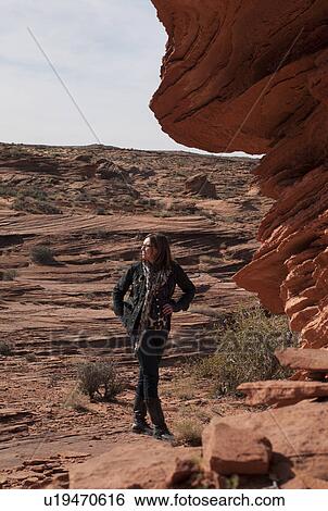 Stock Photograph - Woman standing cliffs, Utah, USA. Fotosearch