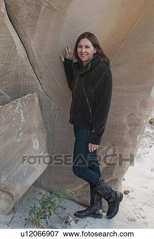 Stock Photo - Woman standing near a cliff posing, Amangiri, Canyon Point, Hoodoo Trail, Utah, USA. Fotosearch