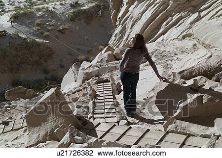 Stock Image - Woman standing near cliffs, Ulrike's Cave, Amangiri, Utah, USA. Fotosearch