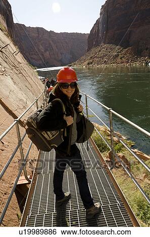 Stock Photograph - Woman standing on a bridge at Glen Canyon Dam, Glen Canyon National Recreation Area, Arizona-Utah, USA. Fotosearch