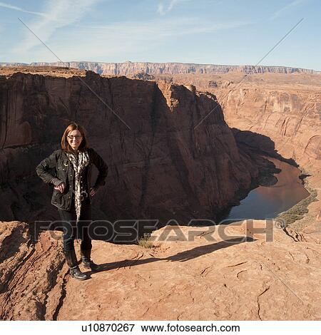 Stock Photo - Woman standing on a rock at Horseshoe Bend, Glen Canyon National Recreation Area, Arizona-Utah, USA. Fotosearch