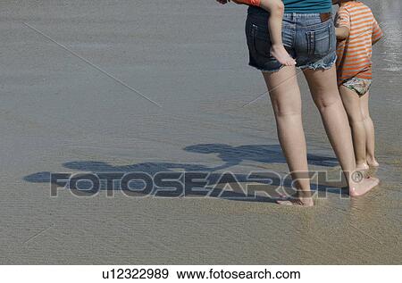 Woman standing on the beach with her two children, Sayulita, Nayarit, Mexico View Large Photo Image Stock Photo - Woman standing on the beach with her two children, Sayulita, Nayarit, Mexico. Fotosearch