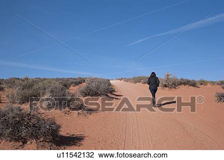 Stock Image - Woman walking in a desert, Horseshoe Bend, Glen Canyon National Recreation Area, Arizona-Utah, USA. Fotosearch